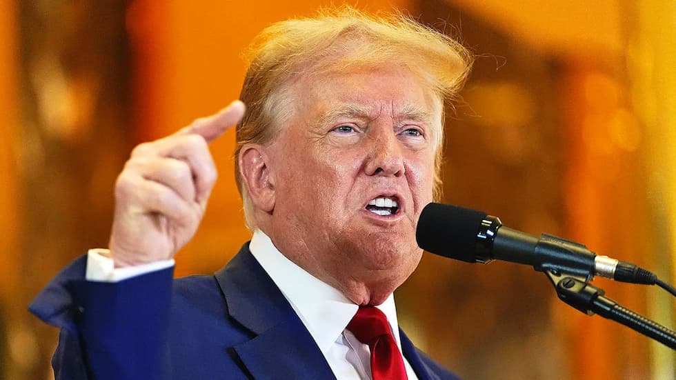 Close up of Donald Trump standing at a lectern and pointing into the crowd.