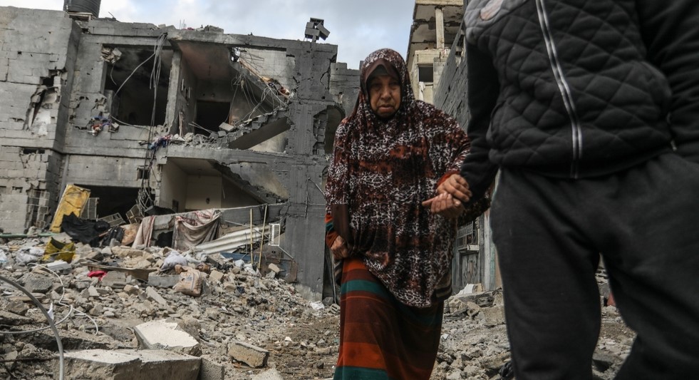 An elderly woman stands in front of a house that has been almost completely destroyed. She is one of the Palestinians inspecting their destroyed homes after an Israeli airstrike in the city of Rafah in the southern Gaza Strip.