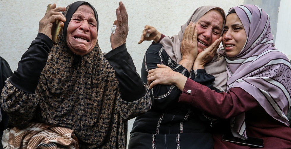 Three Palestinian women mourn their relatives, at Al-Najjar Hospital, after an Israeli air strike, resulting in 15 deaths, in the city of Rafah in the southern Gaza Strip.
